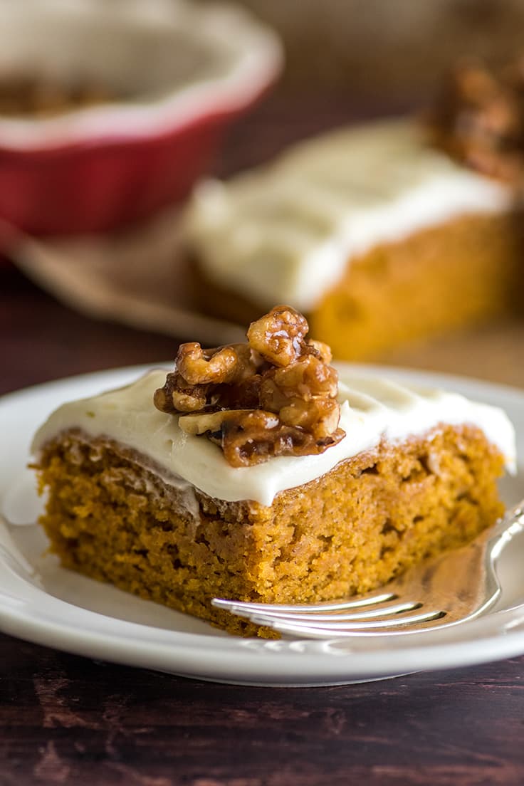 Slice of Mini Pumpkin Cake with cream cheese frosting and candied walnuts.