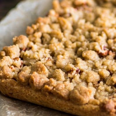 Apple pie bars on parchment paper before being cut.