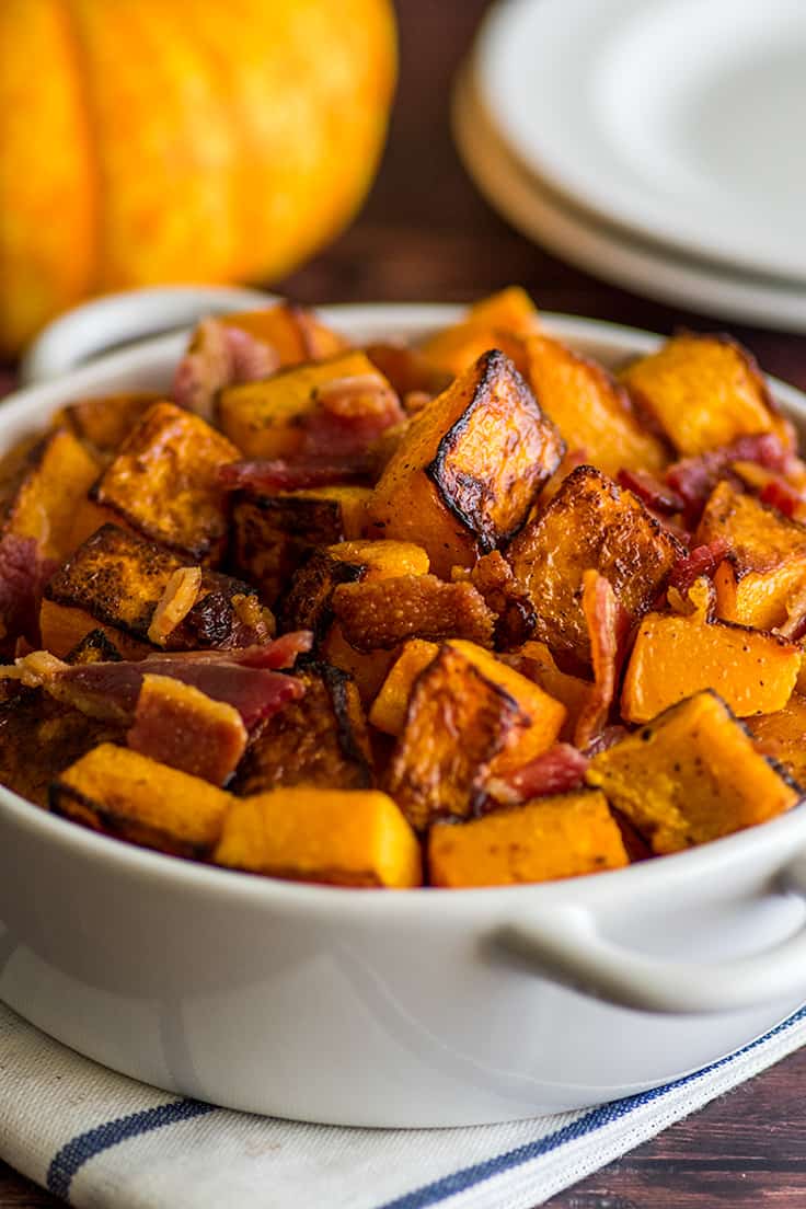 Roasted bacon and butternut squash in a white bowl.