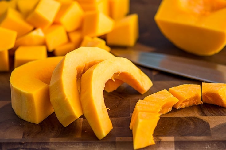 Butternut squash being cut into smaller pieces.