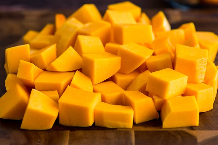 Cut butternut squash on a cutting board.