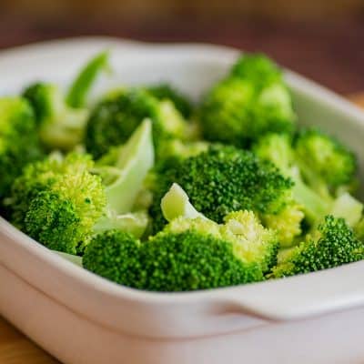 Microwave steamed broccoli in a white dish.