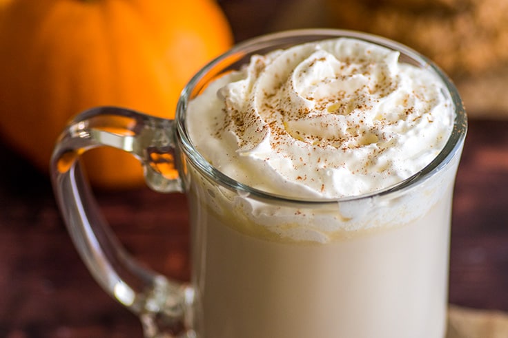 Chai white hot chocolate with whipped cream in a glass mug.