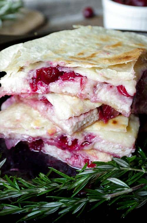 Leftover Cranberry and Turkey Quesadillas stacked next to a sprig of rosemary.