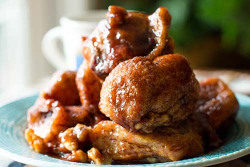 Cranberry and Cream Cheese Monkey Bread piled on a blue plate.