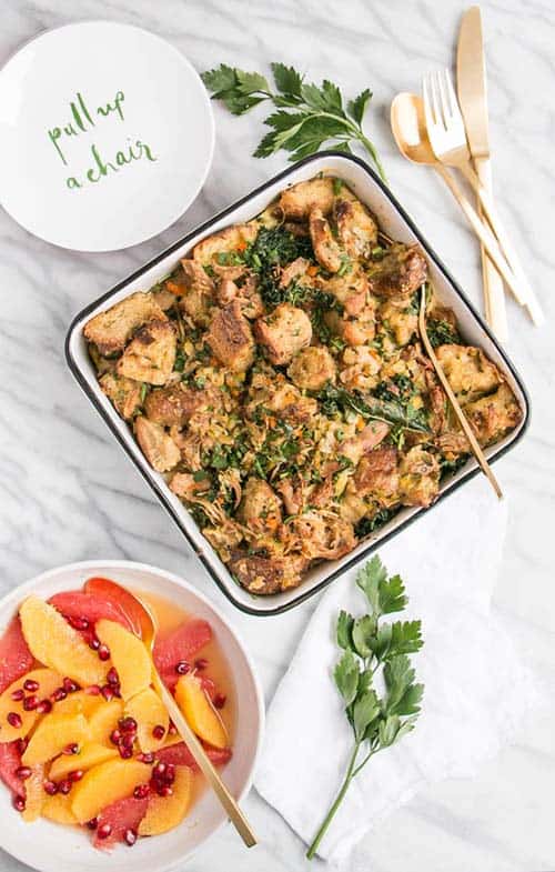 Kale and Stuffing Strata in a white dish on a marble countertop.