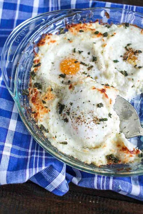 Eggs Baked in Mashed Potatoes in a clear pie pan.
