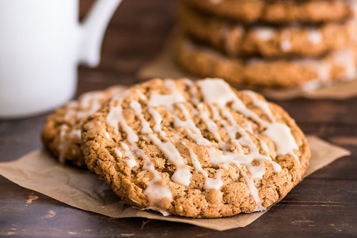 Oatmeal cookies with vanilla glaze on parchment paper.