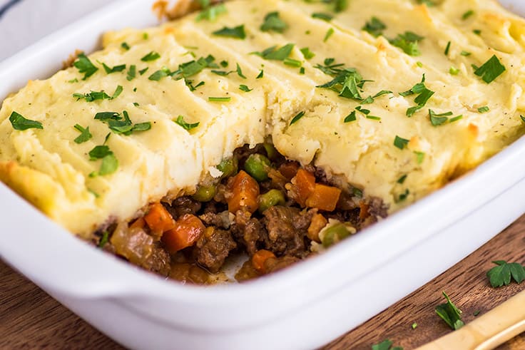 This Easy Shepherd's Pie With Ground Beef recipe is a perfect easy dinner for two or three people. | #dinnerfortwo | #easydinner | #shepherdspie | #groundbeef | Photo of Easy Shepherd's Pie With Ground Beef in casserole dish with beef, carrot, and pea filling showing.