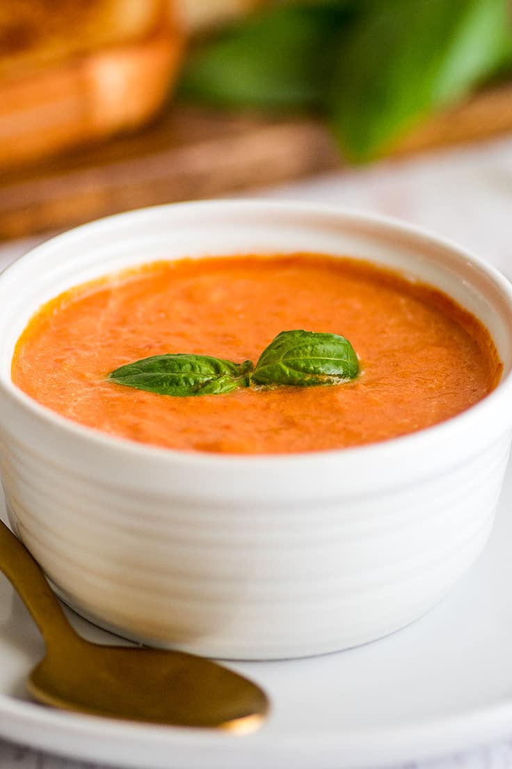 This is the best tomato soup! It serves two and is the perfect quick and easy lunch or dinner. | #tomatosoup | Dinner For Two | Recipe For Two | Photo of Creamy Tomato Soup Recipe for Two with basil leaves on top.
