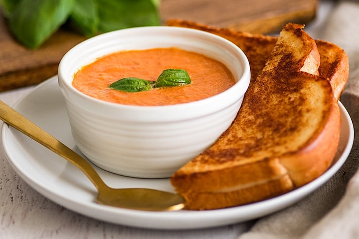 This is the best tomato soup! It serves two and is the perfect quick and easy lunch or dinner. | #tomatosoup | #dinnerfortwo | #recipefortwo | Photo of Creamy Tomato Soup Recipe for Two with grilled cheese sandwich on the side.