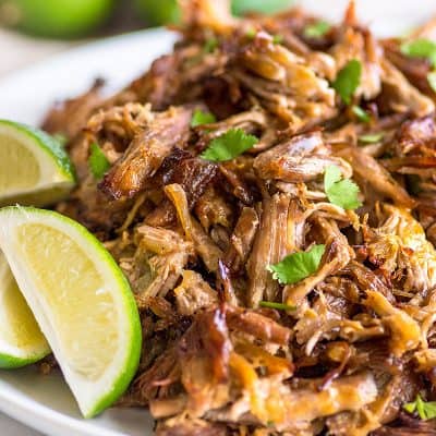 Photo of easy carnitas on a plate with limes.