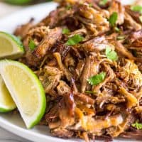 Photo of easy carnitas on a plate with limes.