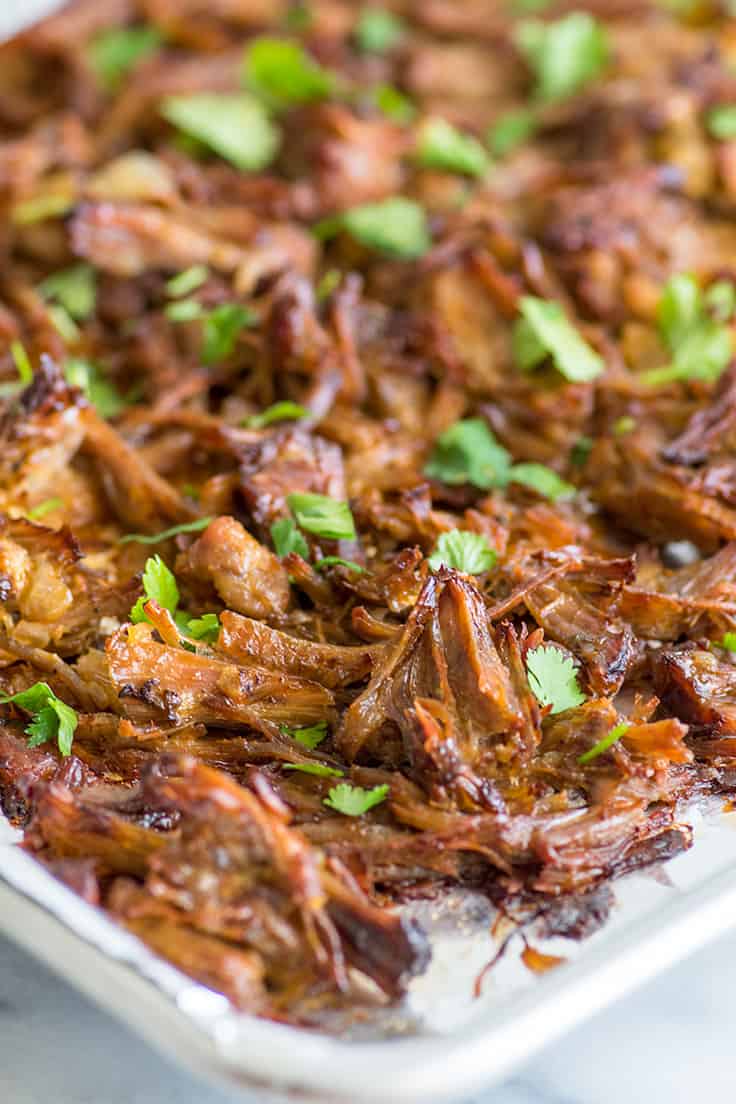 Photo of this easy carnitas recipe shredded and crisped on a baking sheet.