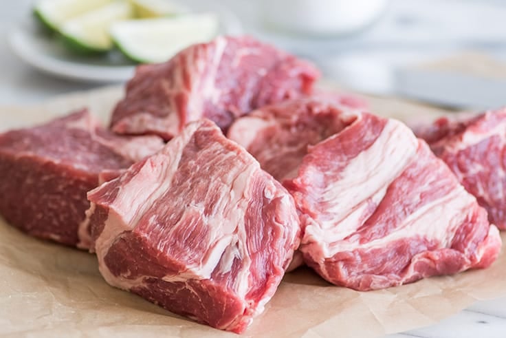 Photo of pork shoulder (pork butt) cut into cubes for carnitas.