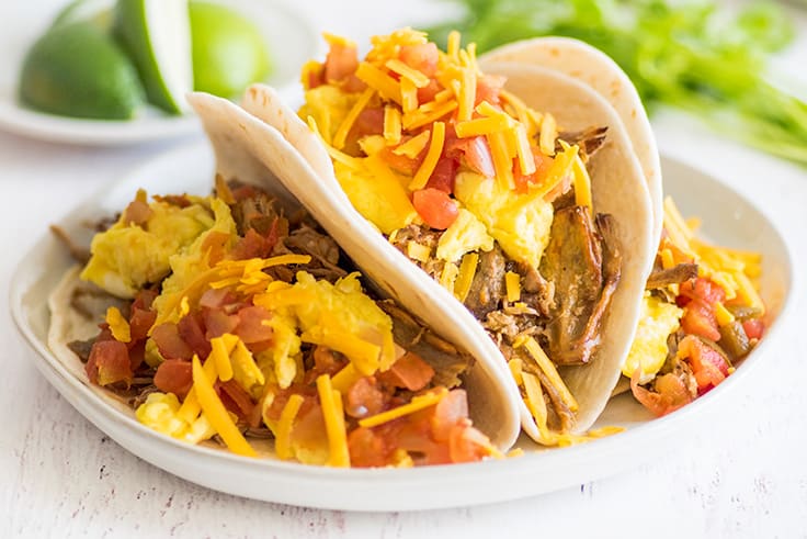 Picture of breakfast carnitas tacos, pork tacos with egg, cheese, and salsa.