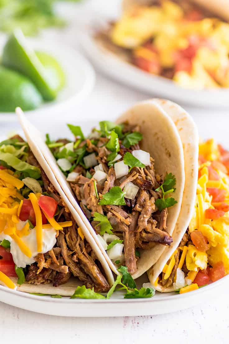 Three different types of carnitas tacos on a plate.