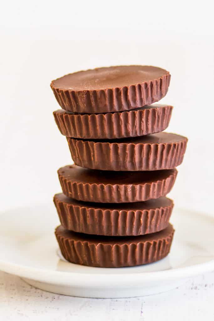Photo of The Easiest Homemade Peanut Butter Cups stacked on a white plate.