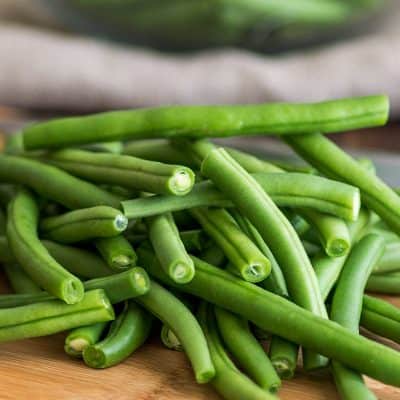 Fresh green beans on a cutting board.
