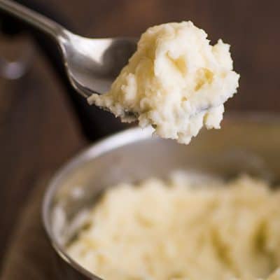 Mashed Potatoes for Two in a pot with a spoonful of potatoes scooped out.