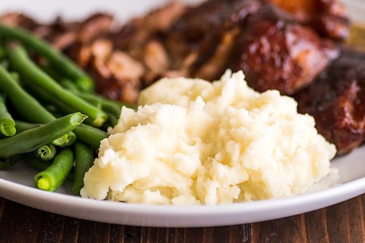 Simple and easy Mashed Potatoes for Two made with one pot and one potato for a quick and easy side dish. | #sidedish | #easy | #recipefortwo | Mashed Potatoes for Two on a plate with ribs and green beans.