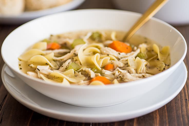 Photo of Easy Chicken Carcass Soup in a white bowl.