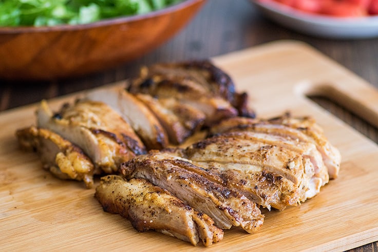 Chicken thighs cut up on a cutting board for Chicken Shawarma Salad.