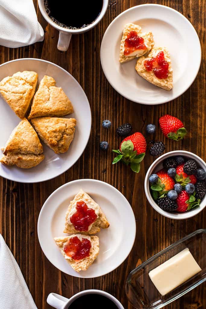 Photo over head shot of table with small batch of cream scones and berries.