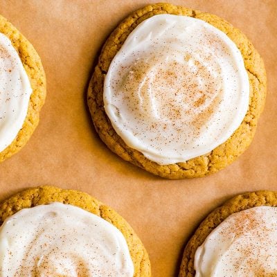 Overhead shot of Small-batch Soft Pumpkin Cookies with Cream Cheese Frosting on parchment paper.