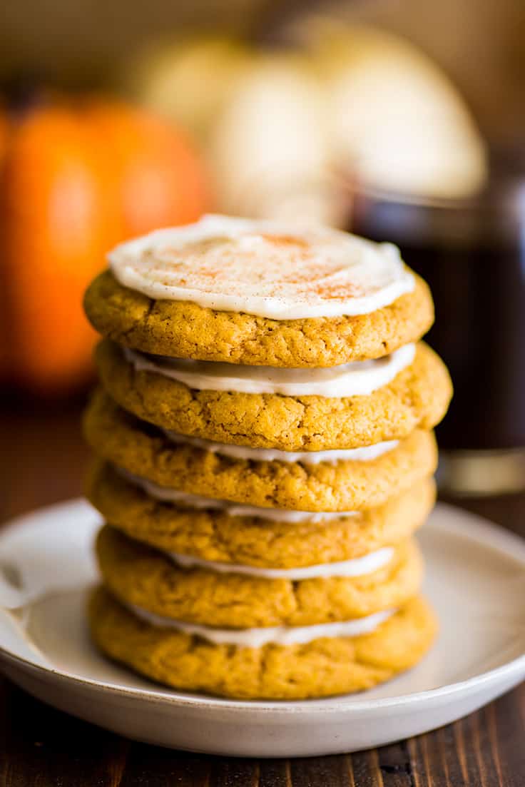 Stack of 6 Small-batch Pumpkin Cookies with Cream Cheese Frosting on a white plate.