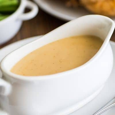 Picture of gravy made from pan drippings in a white gravy boat.