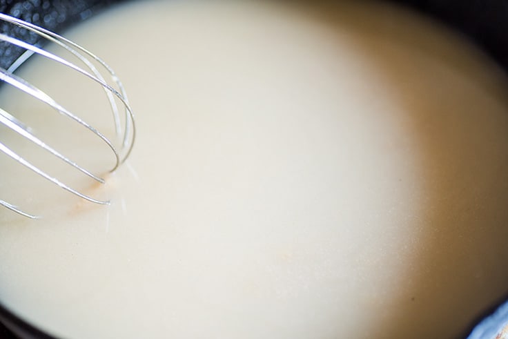 Photo of How to Make Gravy From Drippings step 4: water being whisked into roux.