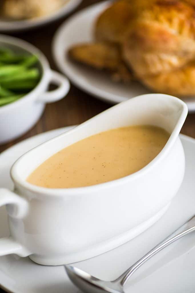 Picture of gravy made from pan drippings in a white gravy boat.