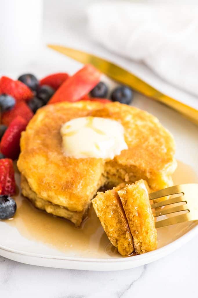 Picture of pancakes for one with a piece out of them.