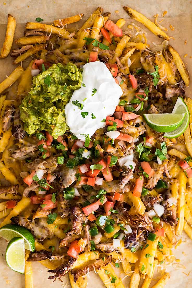 Overhead photo of Carnitas Nacho Fries on parchment paper.