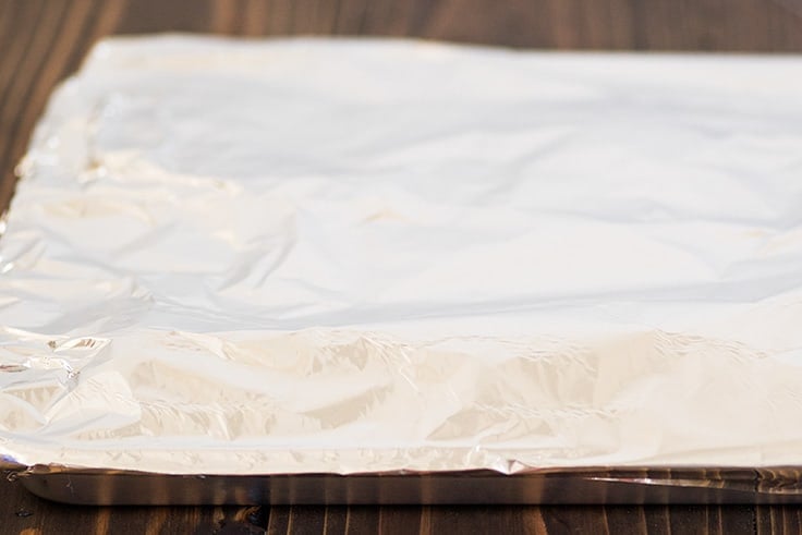 Country-style pork ribs in the oven are the perfect easy dinner. Cheap, easy to make, and SO good, this might be your new favorite way to eat pork. | cheap meals | BBQ | #summer | #summerrecipes | Photo of country-style pork ribs step 2, ribs covered in foil.