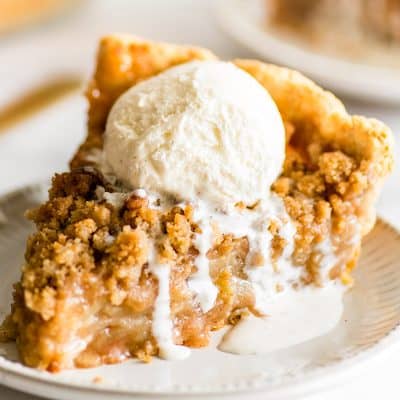 Picture of a slice of Dutch Apple Pie with vanilla ice cream on top.