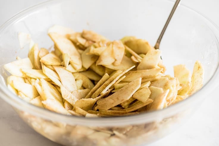 Photo of step 2 of Dutch Apple Pie, sliced apples mixed with sugar and lemon juice.