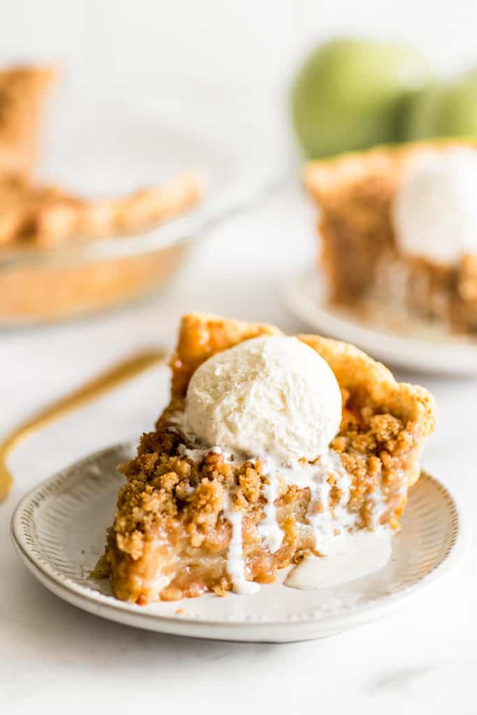 Picture of a slice of Dutch Apple Pie with vanilla ice cream on top.