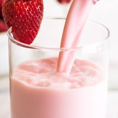 Photo of homemade strawberry milk being poured into a glass.