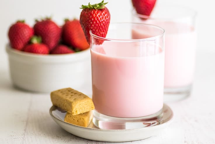 Photo of two cups of homemade strawberry milk.