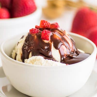 Photo of Nutella sauce over ice cream with strawberries on top.