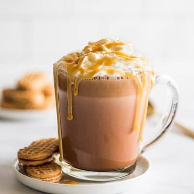 Feature image of Peanut Butter Hot Chocolate on a white plate with Nutter Butter Cookies.