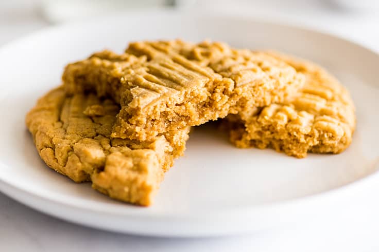 Photo of giant peanut butter cookie in pieces on a plate.