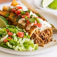 Carnitas Enchiladas (Pulled Pork Enchiladas) on a plate with lettuce.