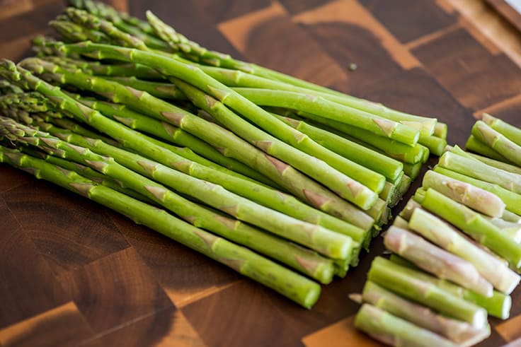 Photo of asparagus on a cutting board with ends trimmed off.