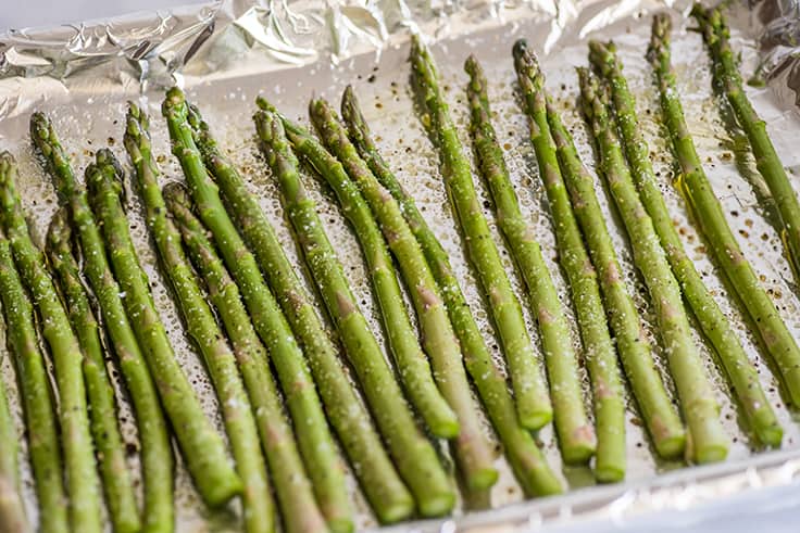 Asparagus in the oven step 2 photo of asparagus on a baking sheet about to be roasted.