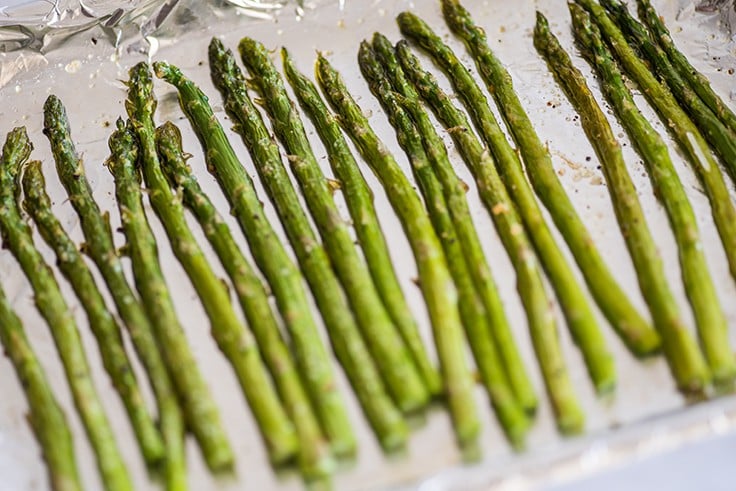 Photo of asparagus cooked in the oven on a cookie sheet.