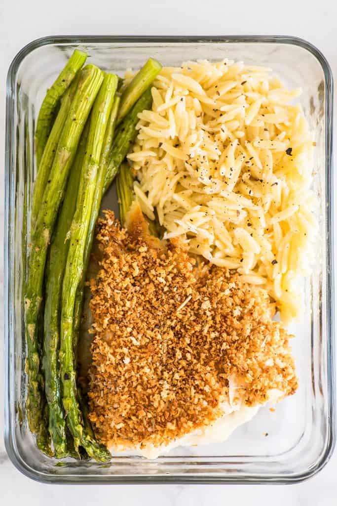 Photo of asparagus cooked in the oven in a meal prep container.