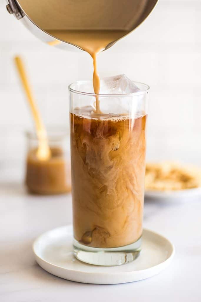 Iced Caramel Macchiato being poured over ice.
